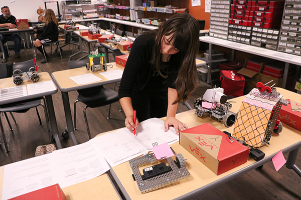 A girl looks through a user manual with a red pen